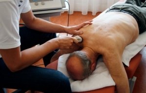 Dr. treating examining painful shoulder patient